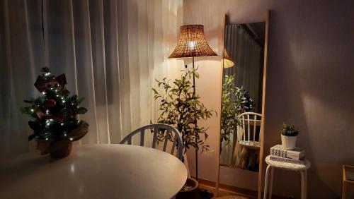 首尔New Corestay # Edae Stn 2min 2R 2F # near Hongdae的一间设有一张桌子、一棵圣诞树和一盏灯的房间