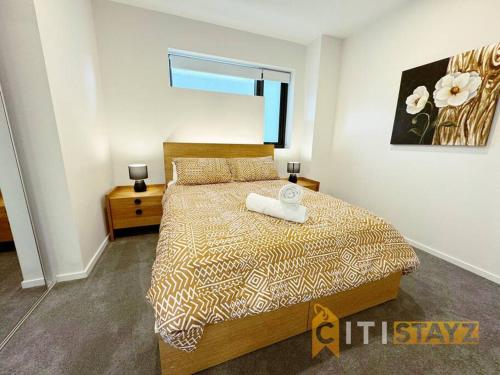 堪培拉Lavish in Lyneham - 2BD 1Bth Apt的一间卧室配有一张床和被子