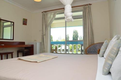 乌昆达ASINS HOLIDAY INN HOTEL的卧室配有白色的床和窗户。