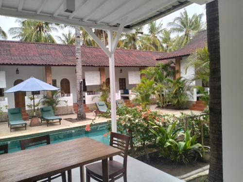 吉利特拉旺安White Coconut Resort的享有带桌椅的庭院景致