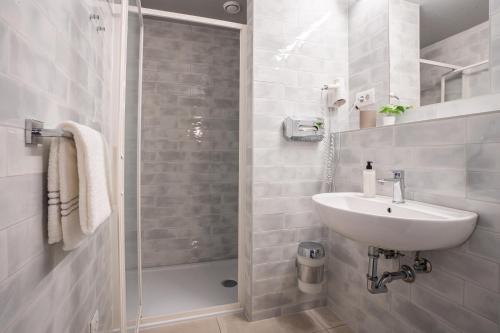 萨尔茨堡harry's XL Hotel的白色的浴室设有水槽和淋浴。