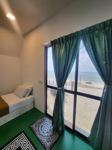 浪中岛DEWATI ROOMSTAY B&B的一间卧室设有窗户,享有海滩美景