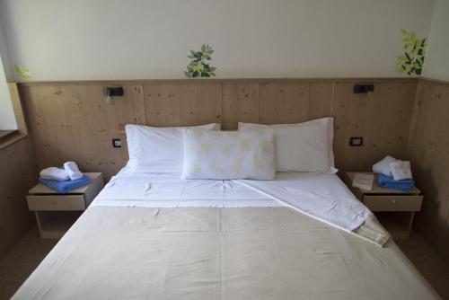 阿拉Agriturismo Maso Rocca的一张配有白色床单和枕头的大床