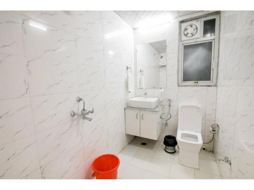 大诺伊达Kusum House的白色的浴室设有水槽和卫生间。