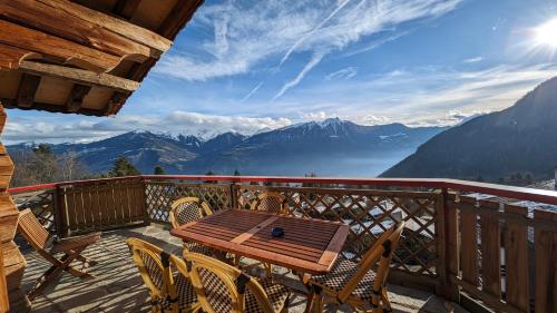 奥瓦伦纳茨Alpenpanorama Ovronnaz的山景阳台上的一张木桌和椅子