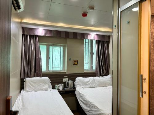 香港香港星星旅馆 b&b的一间医院间,配有两张床和镜子