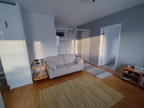 拉彭兰塔Viihtyisä kaksio ydinkeskustassa的客厅配有白色沙发和地毯。