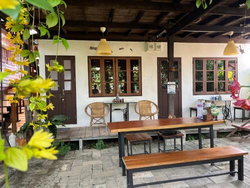 达叻府ครูหนูบ้านพัก แหลมงอบ Krunou baanpak的庭院配有木桌和椅子