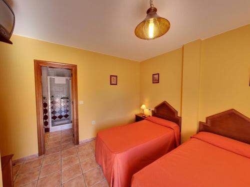 特雷韦莱斯Hotel Rural Pepe Alvarez的带两张床的房间和通往酒窖的门