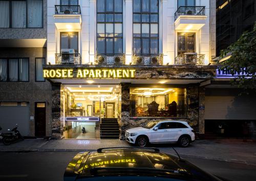 河内Rosee Apartment Hotel - Luxury Apartments in Cau Giay , Ha Noi的停在大楼前的白色汽车