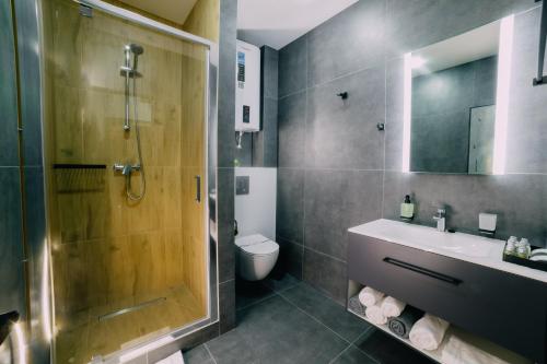 赫梅利尼克Rado Hotel Spa的带淋浴、盥洗盆和卫生间的浴室