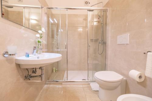 莱乌卡Hotel Magna Grecia的带淋浴、卫生间和盥洗盆的浴室