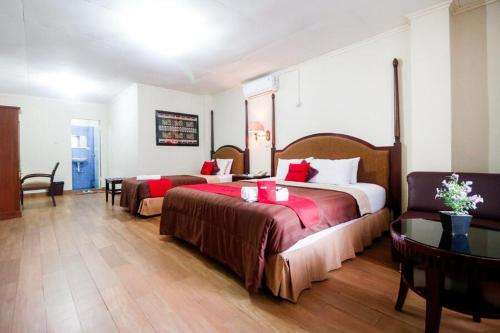 班达楠榜RedDoorz Plus @ Jalan Raden Intan Lampung的酒店客房设有两张床和一张桌子。