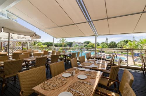 阿尔布费拉阿尔法加公寓式酒店的一间带桌椅的餐厅和一个游泳池