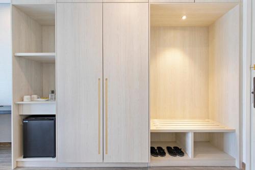岘港Danang Bay View Apartment - Phòng Code chủ的衣柜配有白色橱柜和黑冰箱