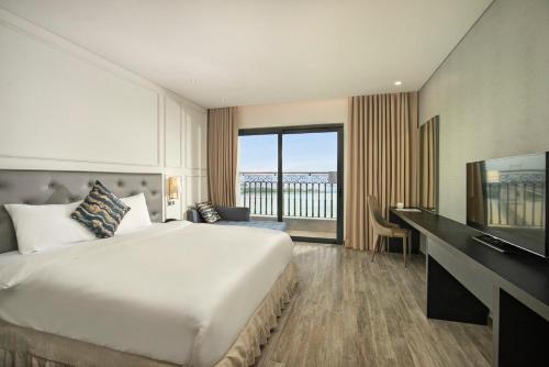 岘港Danang Bay View Apartment - Phòng Code chủ的酒店客房设有一张大床和一台电视。
