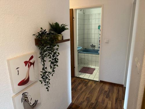 不莱梅Bremen Ferienwohnung的走廊上设有带淋浴和植物的浴室