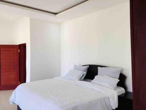 卢萨卡Executive 4 bedroom house with 4 beds .的一间卧室配有带白色床单和枕头的床。