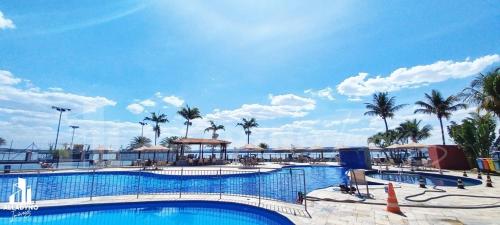 巴西利亚Luxuoso Flat em resort vista incrível para o Lago的一座棕榈树环绕的大型游泳池