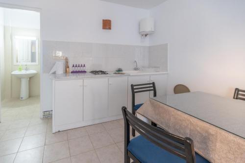 迈来亚CoZi Coliving space Djerba的厨房配有白色橱柜和桌椅