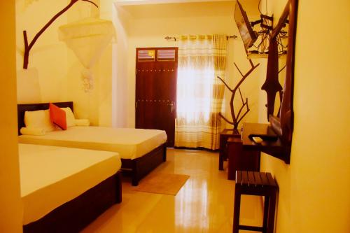 达瓦拉维Royal Inside Hotel的酒店客房设有两张床和窗户。