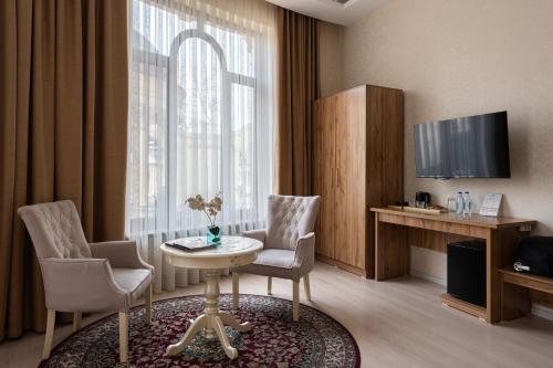 塔什干Shoxjahon Hotel - 600 Mbps Internet的客厅配有桌椅和电视。