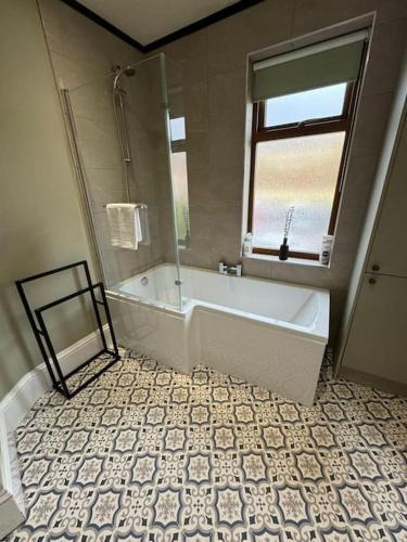 MytholmroydLovely home with a river view的带浴缸的浴室和窗户。