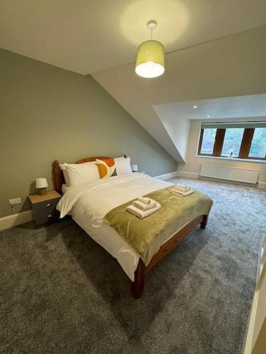 MytholmroydLovely home with a river view的一间卧室配有一张大床和两条毛巾