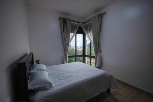 WakisoApartment at Pearl Marina - Garuga Road的一间卧室设有一张床和一个窗口