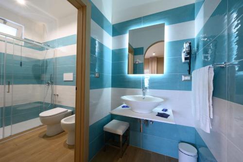 皮肖塔Villaggio Stella del Sud & Resort的蓝色和白色的浴室设有水槽和卫生间