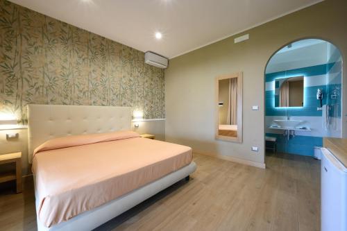 皮肖塔Villaggio Stella del Sud & Resort的一间卧室配有一张床,浴室设有水槽