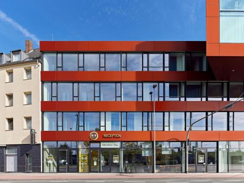 明斯特B&B HOTEL Münster Hafen的红玻璃外墙的办公楼