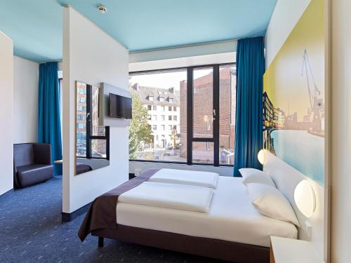 明斯特B&B HOTEL Münster Hafen的一间卧室设有一张床和一个大窗户