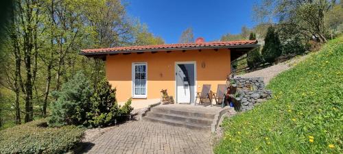 索内贝格Ferienhaus - Bungalow的一座橙色的小房子,前面有两把椅子