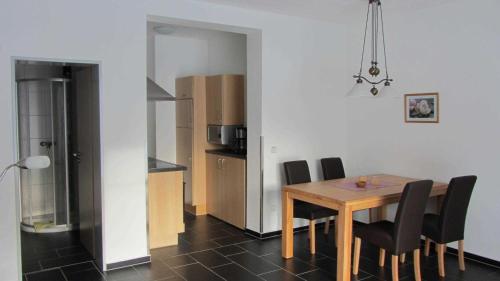 NeuenbauAm Alten Forsthaus的一间带桌椅的用餐室和一间厨房