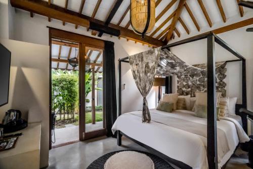 坎古Bloom Resort Bali by BaliSuperHost的一间卧室配有一张带天蓬的床