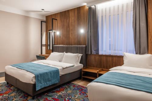 普里什蒂纳Hotel Square by MARGO的酒店客房设有两张床和窗户。