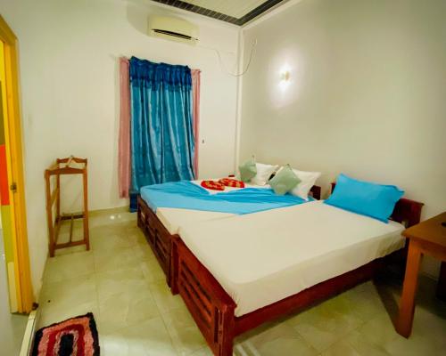 蒂瑟默哈拉默Happy Resort Yala的一间卧室配有蓝色和白色床单