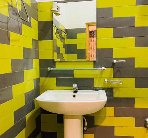 蒂瑟默哈拉默Happy Resort Yala的黄色和黑色的浴室设有水槽和镜子