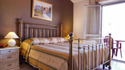 阿尔盖罗圣马可酒店的一间卧室配有一张床和一张带台灯的桌子