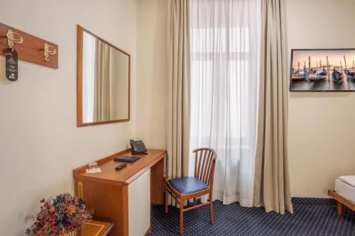 布尔诺欧罗巴酒店的酒店客房配有书桌和床。