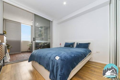 悉尼Aircabin - Burwood - Sydney - 2 Beds Apt Free Park的一间卧室设有一张大床和一个大窗户