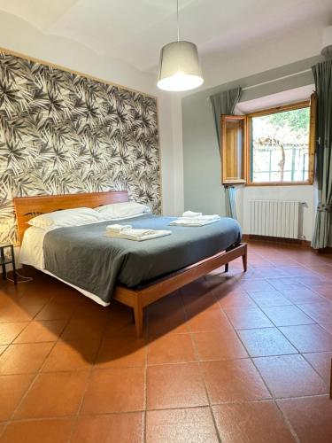 佛罗伦萨Leopoldini Appartamenti的一间带床的卧室,位于带窗户的房间内