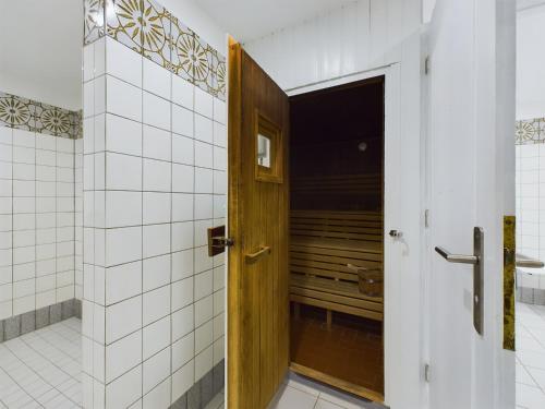 威克奥夫弗尔Oland Whg 13 Seestern的浴室设有白色瓷砖,设有木门