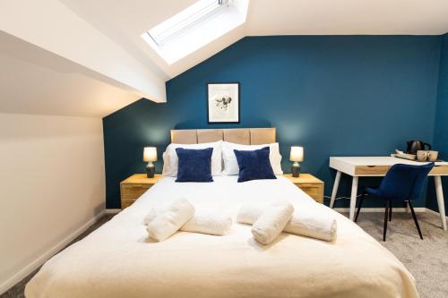 奥尔德姆Suite 7 - Family Room in the Heart of Oldham的一间卧室配有一张带蓝色墙壁的大床