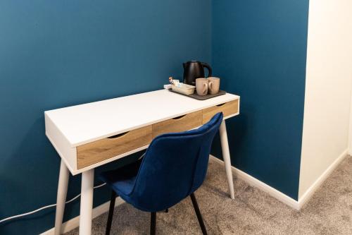 奥尔德姆Suite 7 - Family Room in the Heart of Oldham的一张带蓝色墙壁和蓝色椅子的桌子