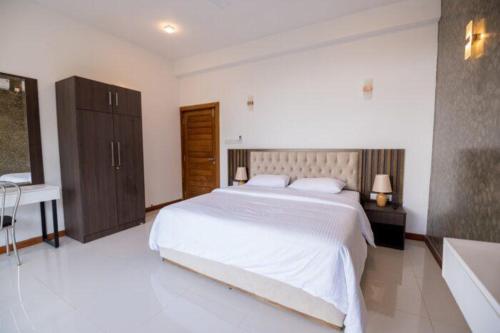 康提Kings Hantana的卧室配有一张白色大床和浴缸