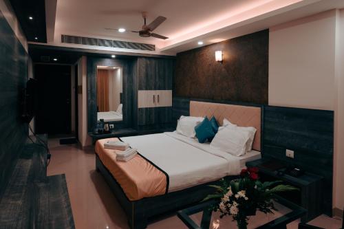 昆达普拉Hotel Samudyatha Inn And Suites的一间卧室配有一张大床和电视