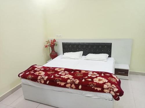 BulandshahrAnand Family Restaurant的一间卧室配有一张床铺,床上铺有红色毯子