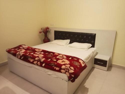 BulandshahrAnand Family Restaurant的一间卧室配有一张床铺,床上铺有红色毯子